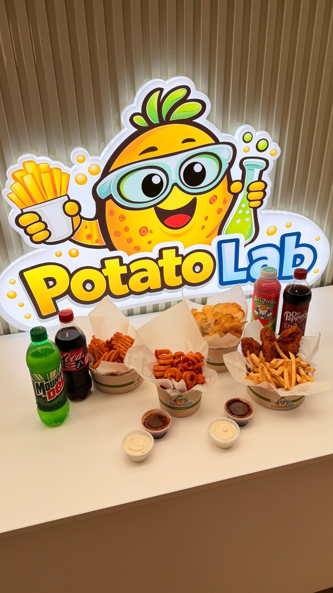 Potato Lab food display in front of the illuminated logo