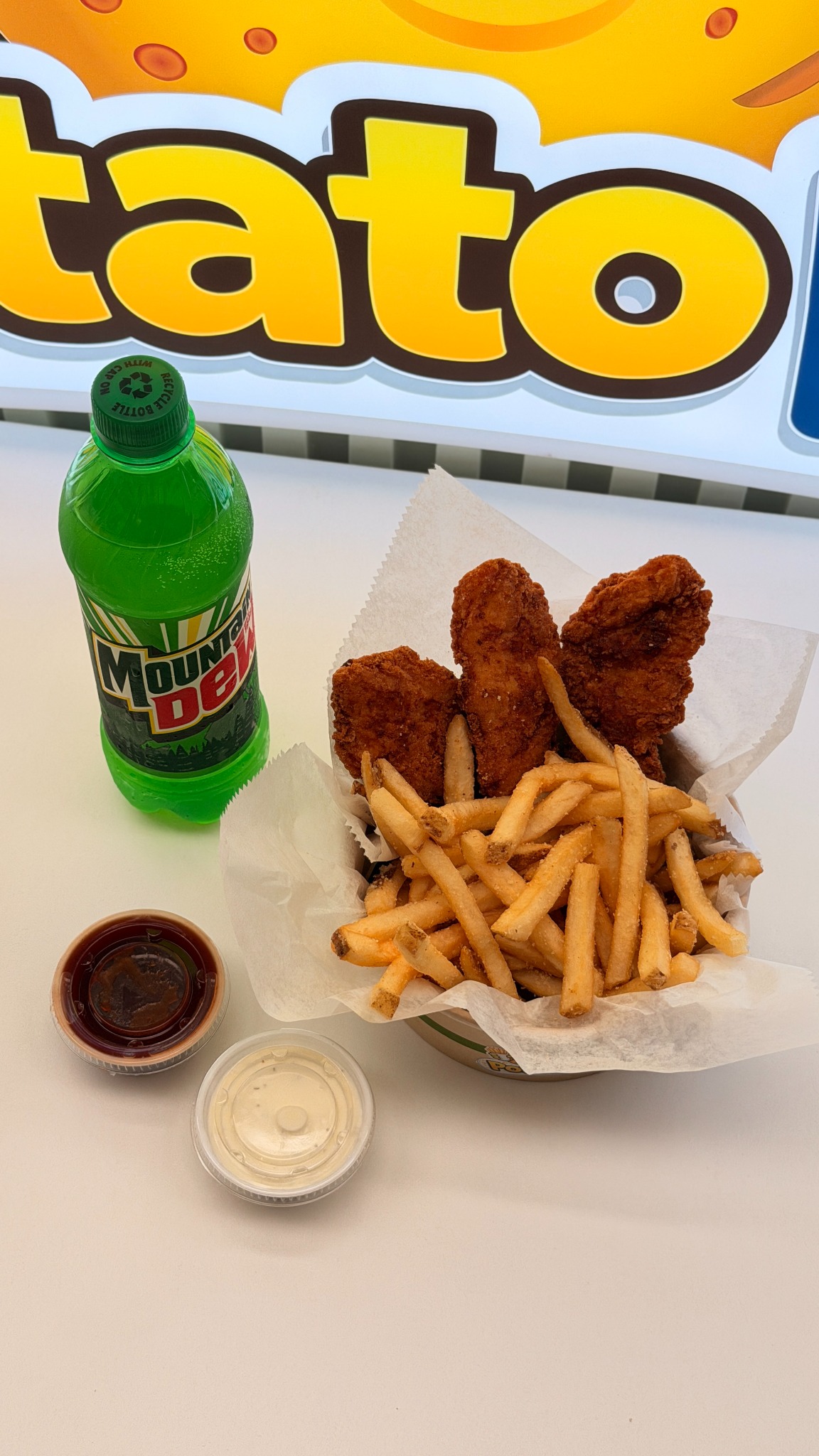 Chicken tenders, fries, sauces, and bottled drink